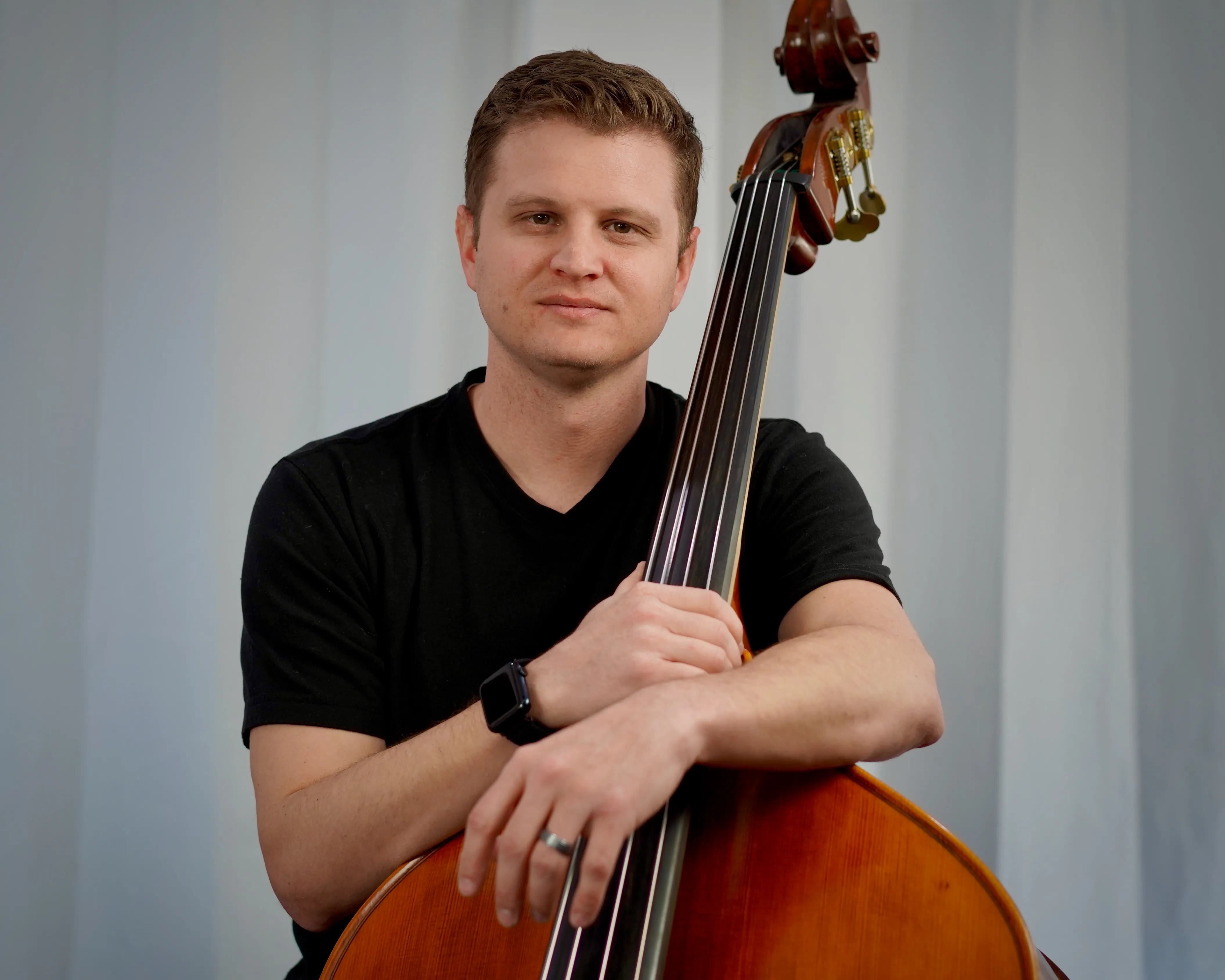Trevor Watson holding upright bass looking into camera